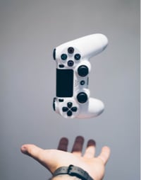 A playstation controller falling upon someone's palm.